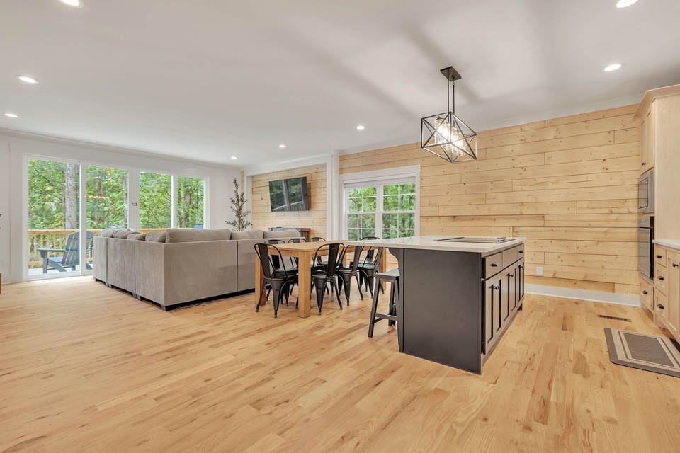 Beautiful gourmet kitchen and living room featuring wood views. 
