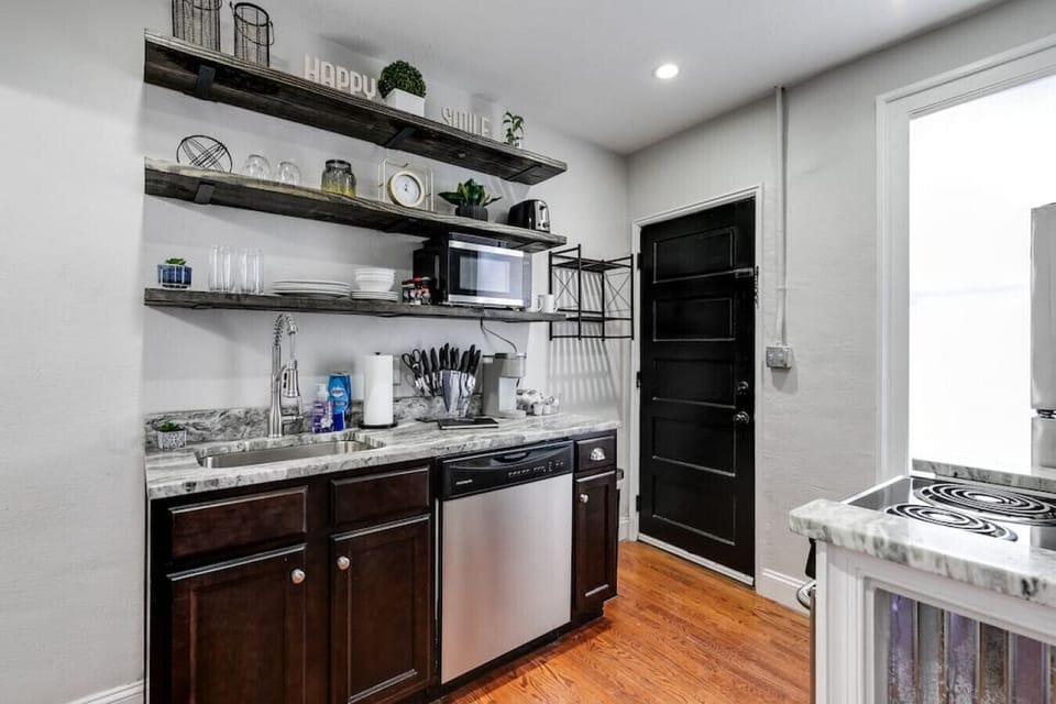 Well-appointed kitchen with open shelving, microwave, toaster, Keurig coffee maker, electric stove, dishwasher, fridge, freezer and more!