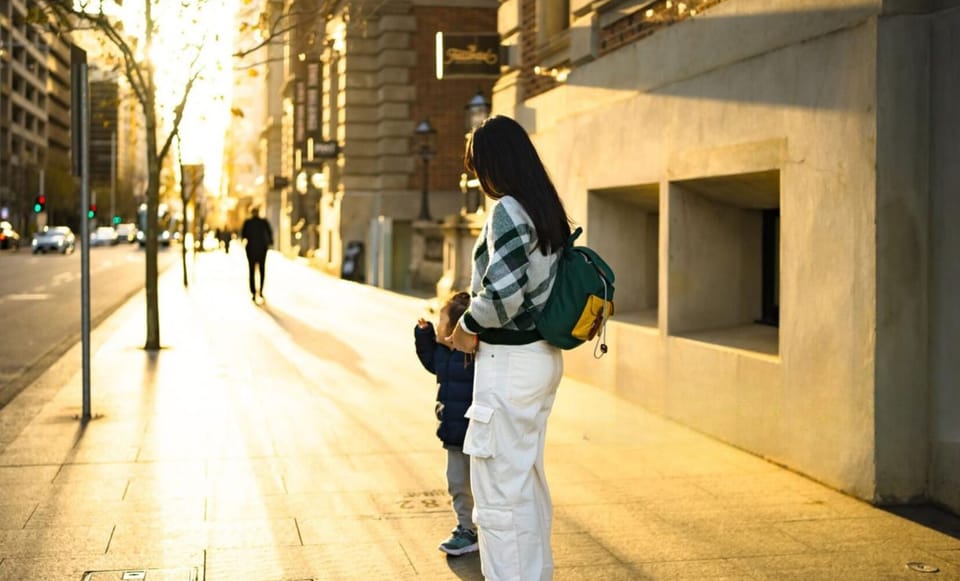Stroll through golden-lit streets, where warm sunlight filters through the trees, casting a dreamy glow on the city. A peaceful walk filled with connection and quiet charm.
