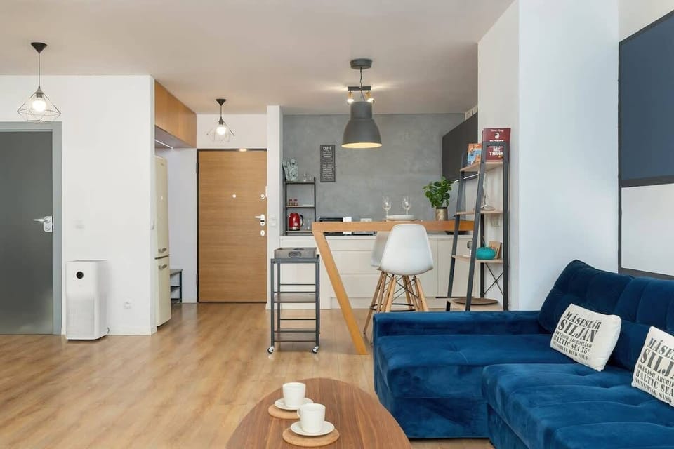 A spacious open-plan interior with wooden floors, stylish furniture, and a seamless connection between rooms.


