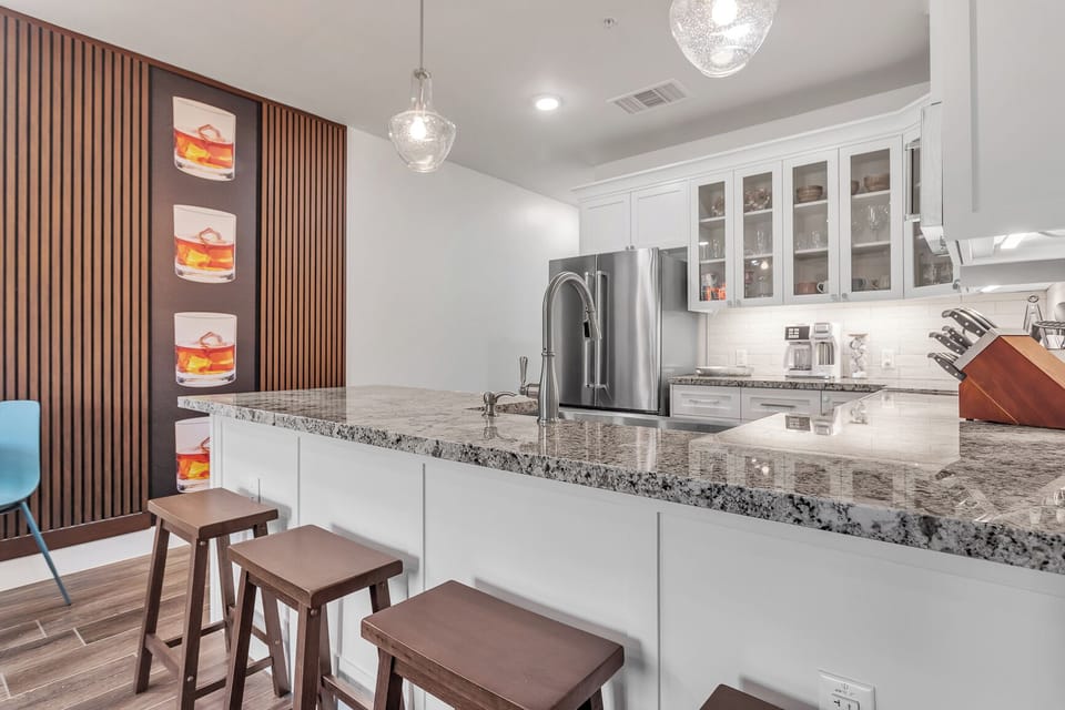 Feature wall and beautiful kitchen with barstools at the bar!