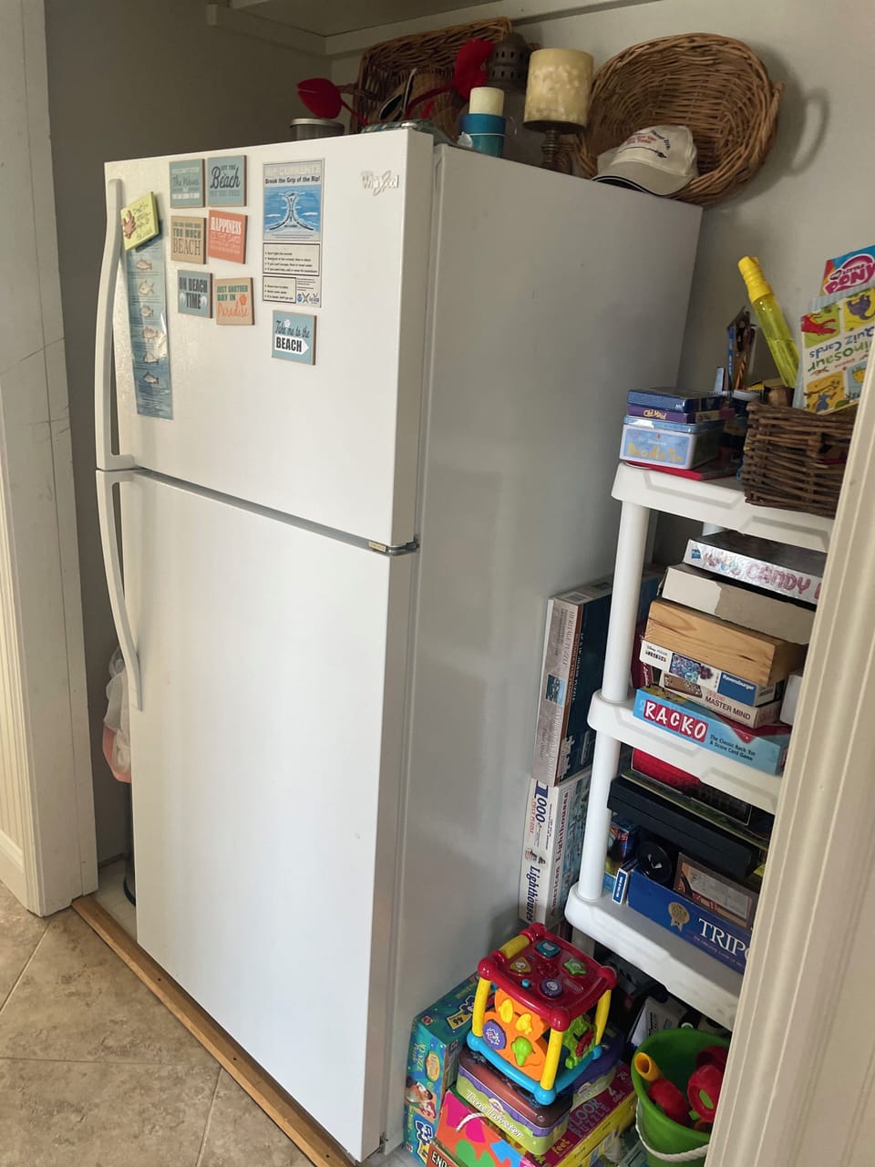 Upper level hall storage area w/ extra refrigerator and games, toys and puzzle.