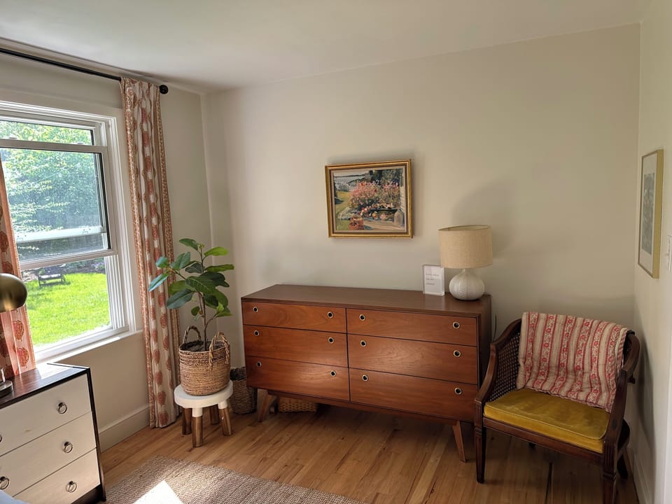 Bedroom 1 with queen sized bed and view of backyard gardens
