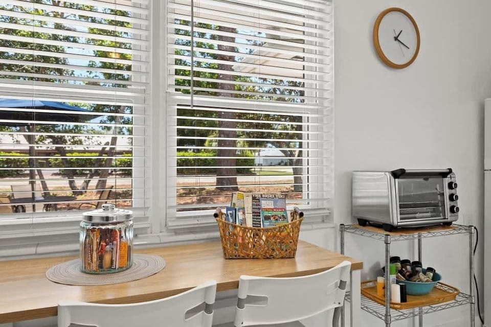 Dinette table for two, welcome brochures, treats for guests, air fryer, and spices. 
