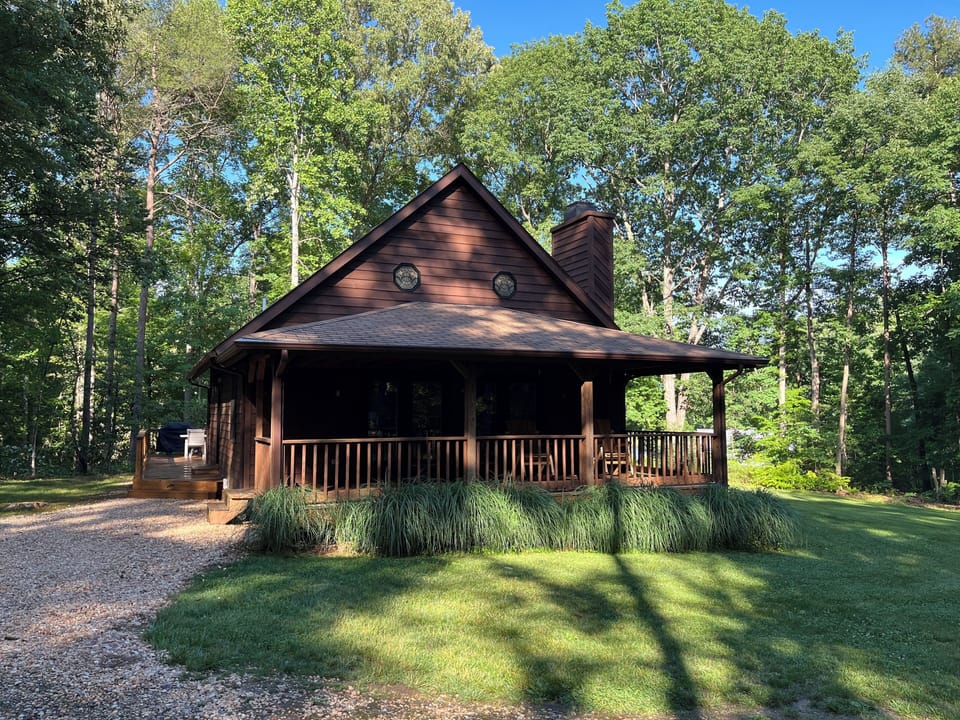Calm Water Cabin in the spring - surrounded by lush green grasses and trees.