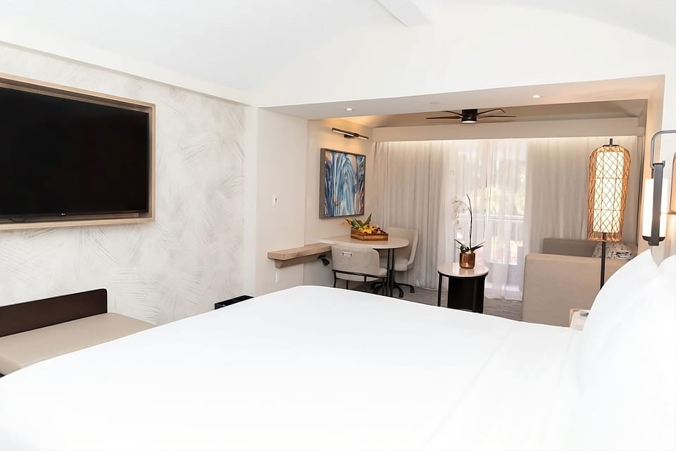 Unwind in crisp linens with TV and cozy seating.