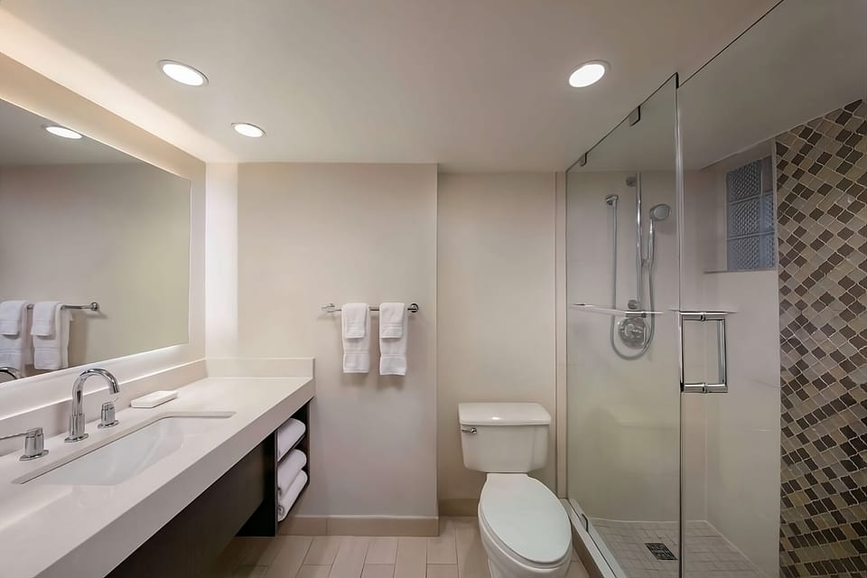 Refresh in a spotless, bright bathroom with glass shower.