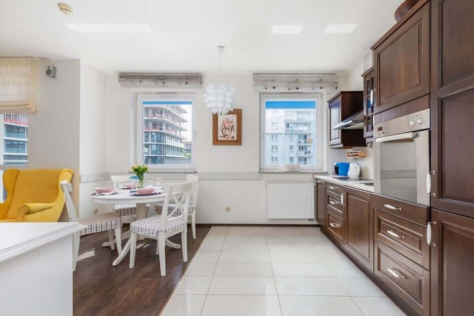 A dining area connected to the kitchen, featuring a bright space with classic wooden furniture.
