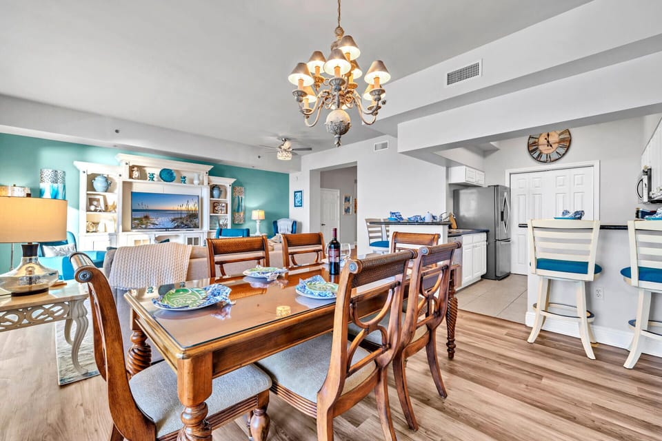 Your elegant dining space flows seamlessly into the kitchen, where coastal colors and warm lighting create the perfect atmosphere for memorable meals.