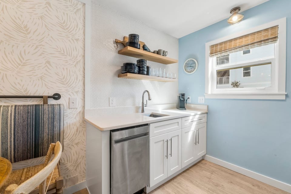 Compact kitchen with modern white cabinetry and open shelving for storage