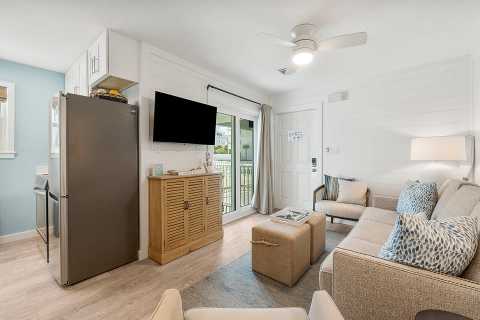 Cozy living area with a wall-mounted tv and sliding door to the balcony.