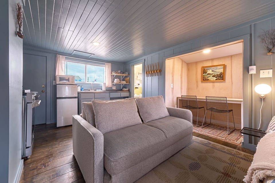 A stylish sofa neatly separates the bedroom and kitchen areas, maximizing comfort and functionality.