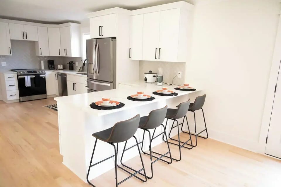 Open space kitchen to the living room, features 4 siting chairs, 