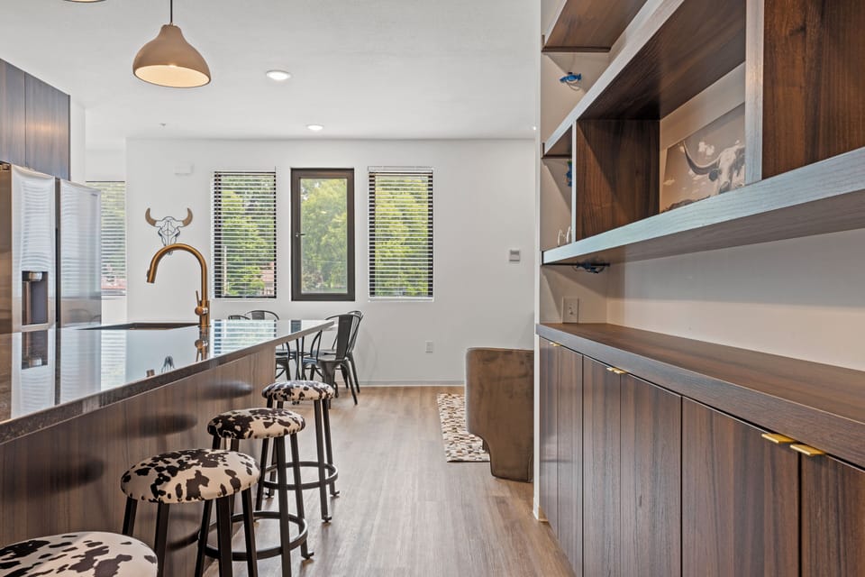 Modern kitchen with a large island and bar seating, offering a perfect spot for breakfast, coffee, or casual meals. Bright, open layout ideal for a comfortable stay in walkable Downtown Shawnee.