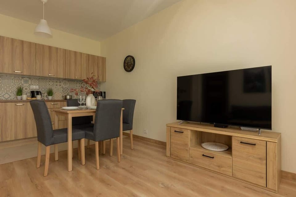 A view of the open-plan space, showcasing the dining table and TV area.
