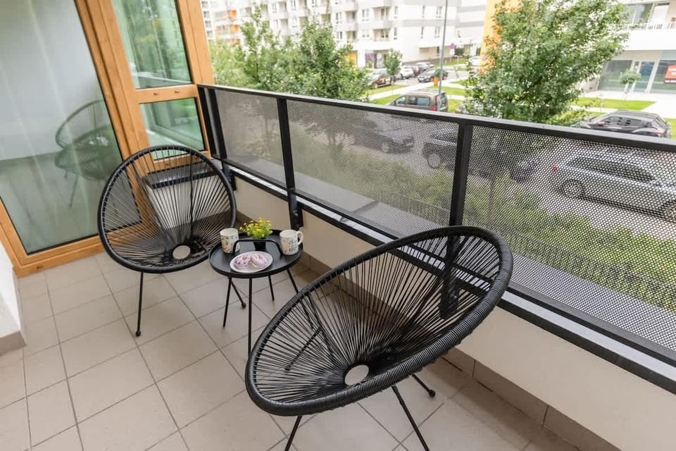 A second look at the balcony, featuring comfortable seating and a glimpse of city greenery.


