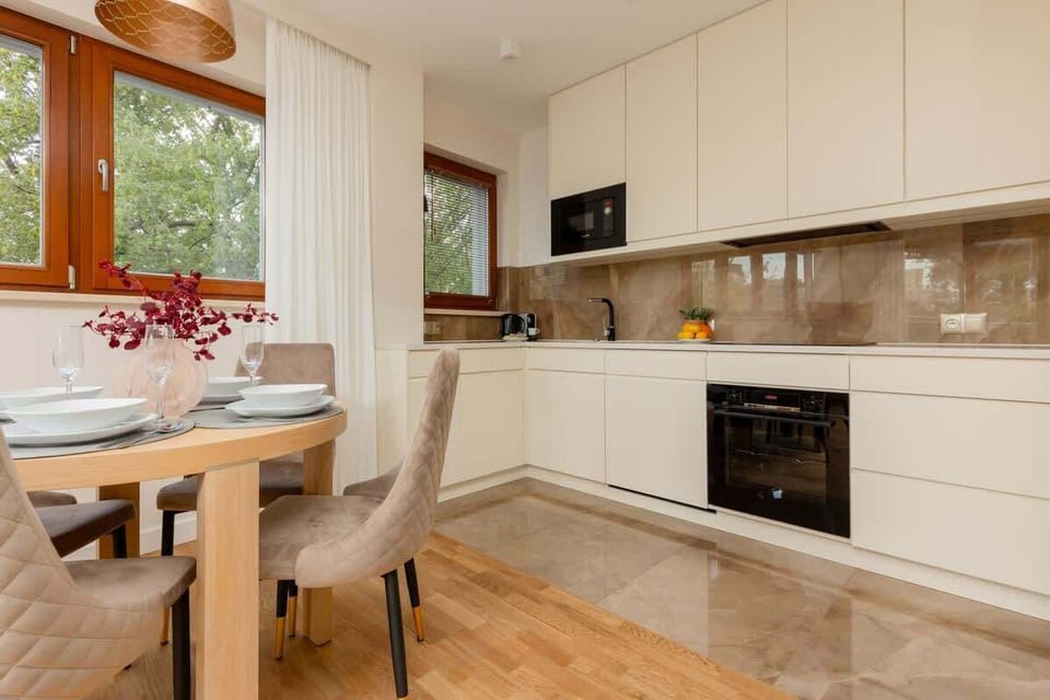 A modern kitchen with white cabinetry, integrated appliances, and a spacious design for meal preparation.

