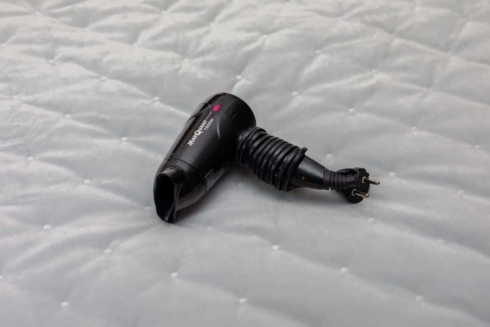 A thoughtful amenity detail a hairdryer placed on the bed, ensuring guests have everything they need for their stay.









