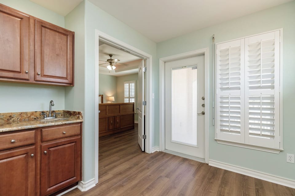 Your private kitchenette features warm cherry cabinets and granite counters, with elegant shutters framing natural light.