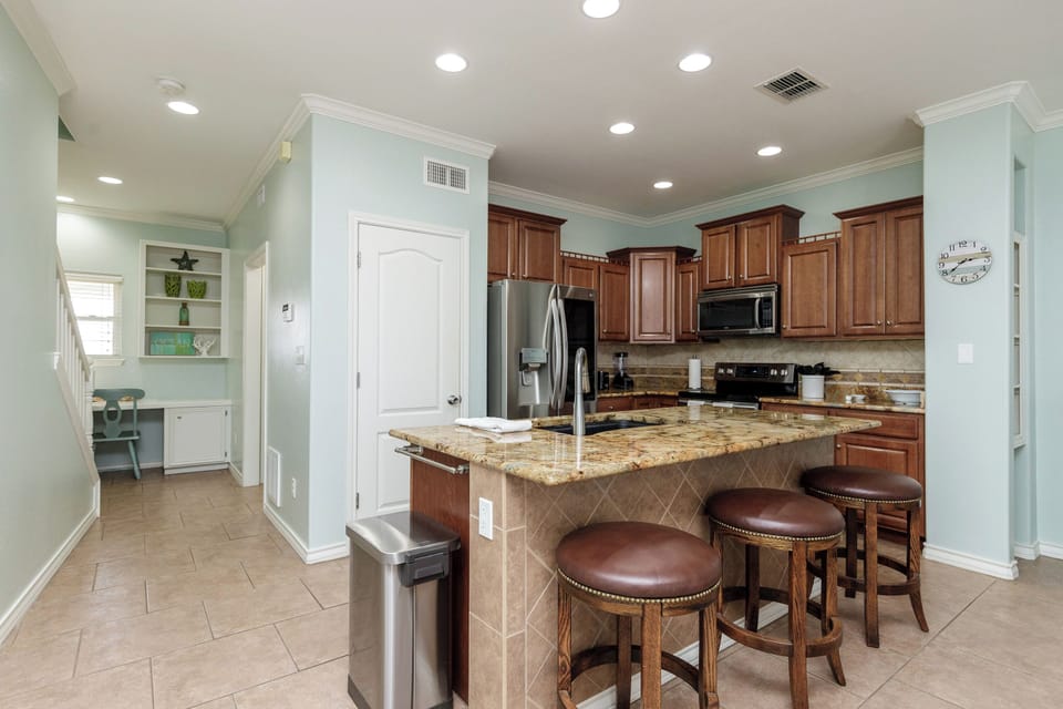 Your gourmet kitchen awaits with granite countertops, rich cherry cabinets, and a breakfast bar perfect for morning coffee.