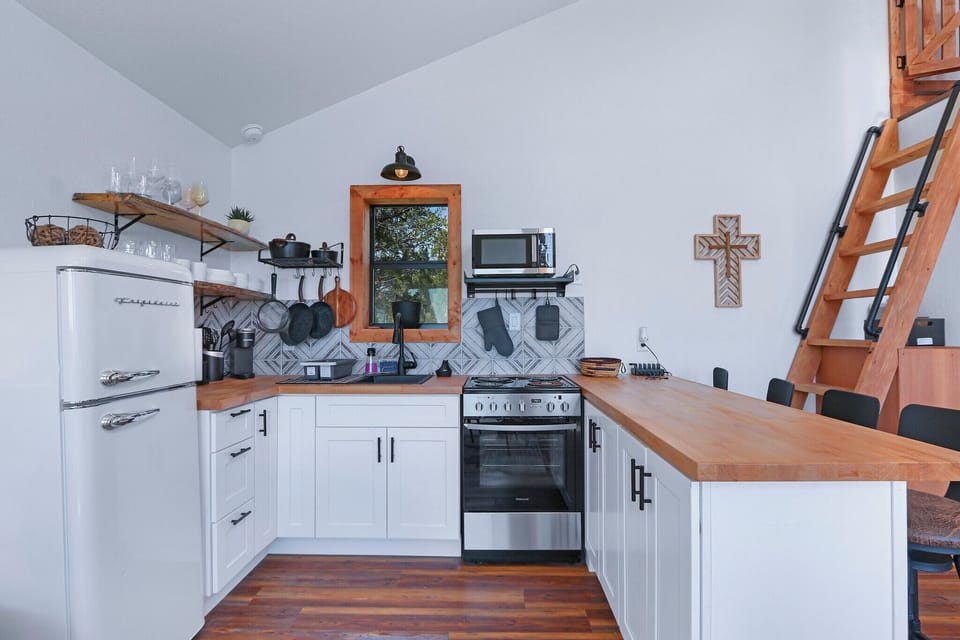 The kitchen is stocked with a stovetop/oven and refrigerator