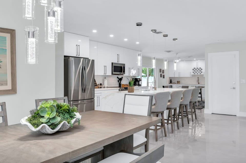 The dining area features a 6-person dining table perfect for your group feasts. There are 4 additional counter stools at the impressive quartz waterfall island.