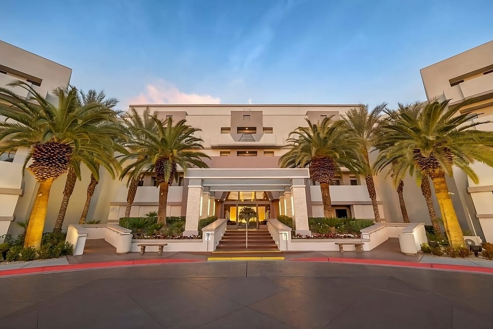 Step into a grand palm-lined entrance glowing at golden hour.