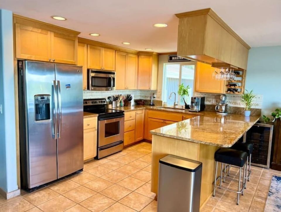 Open-concept kitchen with Puget Sound views, gourmet pots, utensils & coffee