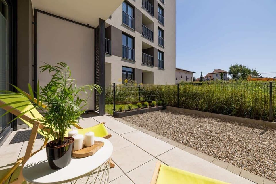 An outdoor patio with greenery and a small seating area, perfect for relaxing in a peaceful environment.

