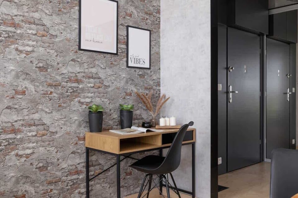 A textured brick accent wall with a small table and decorative elements, adding charm and character to the space.


