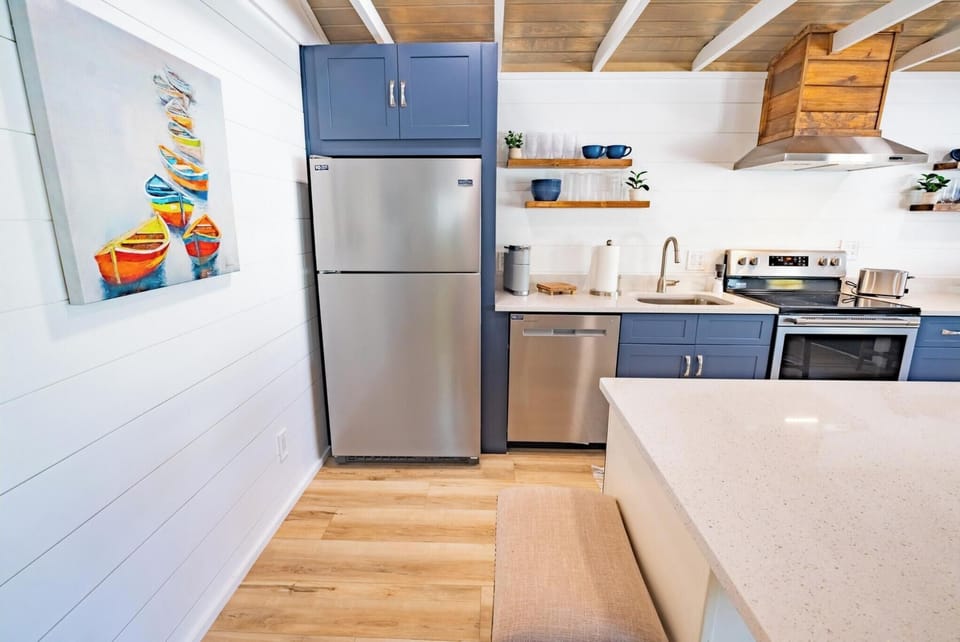 modern kitchen with stainless steel appliances and blue cabinetry