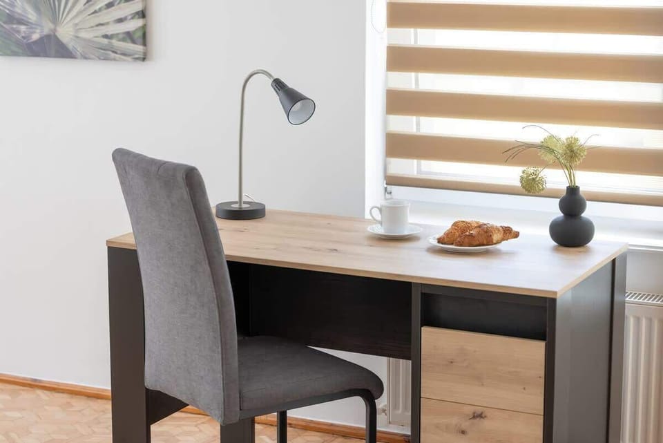 Functional workspace with a desk and chair, accented by a small plant for a touch of greenery.

