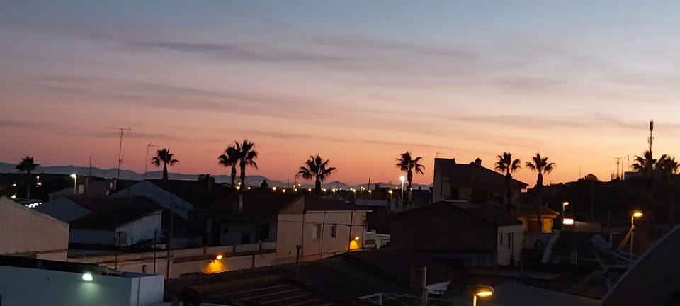 sun setting over the village rooftops and beyond, photo from roof terrace. 
