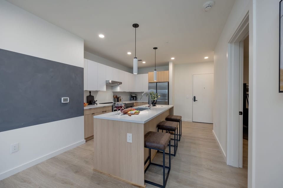 Kitchen stocked with all culinary essentials and fully equipped with brand-new stainless-steel appliances. Features an island with bar seating.