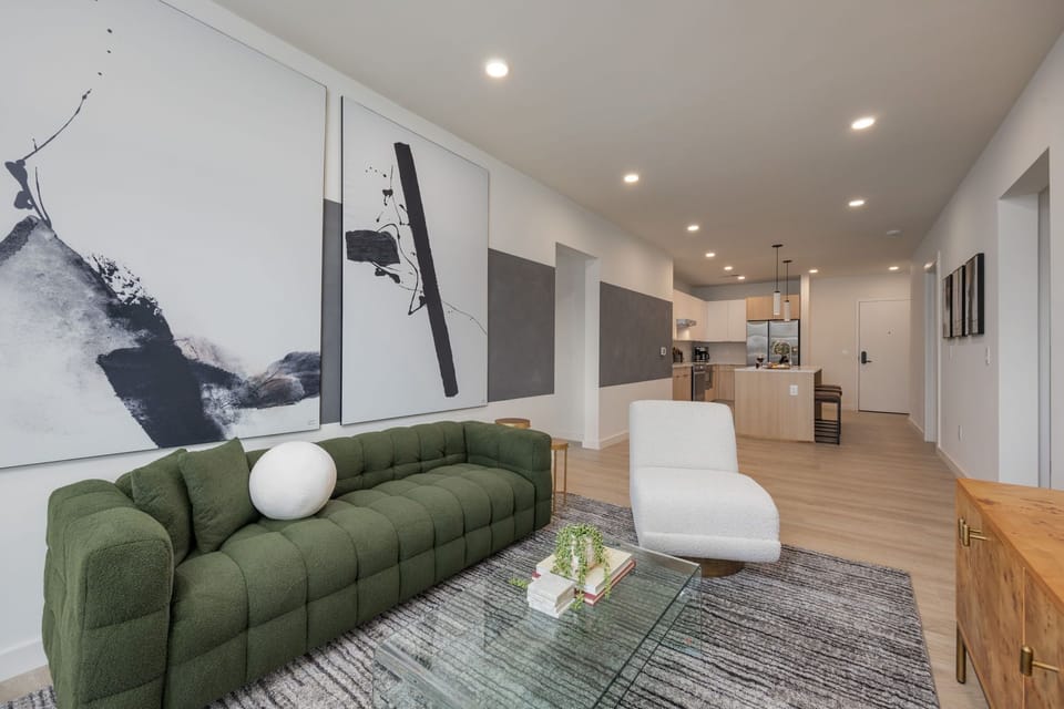 Cozy modern living room featuring a Smart TV, Patio access with city views and designer decor with plush furnishings.