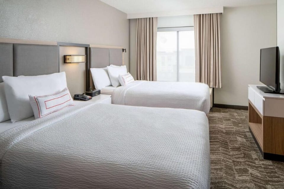 Drift off comfortably in a bright room with two beds.