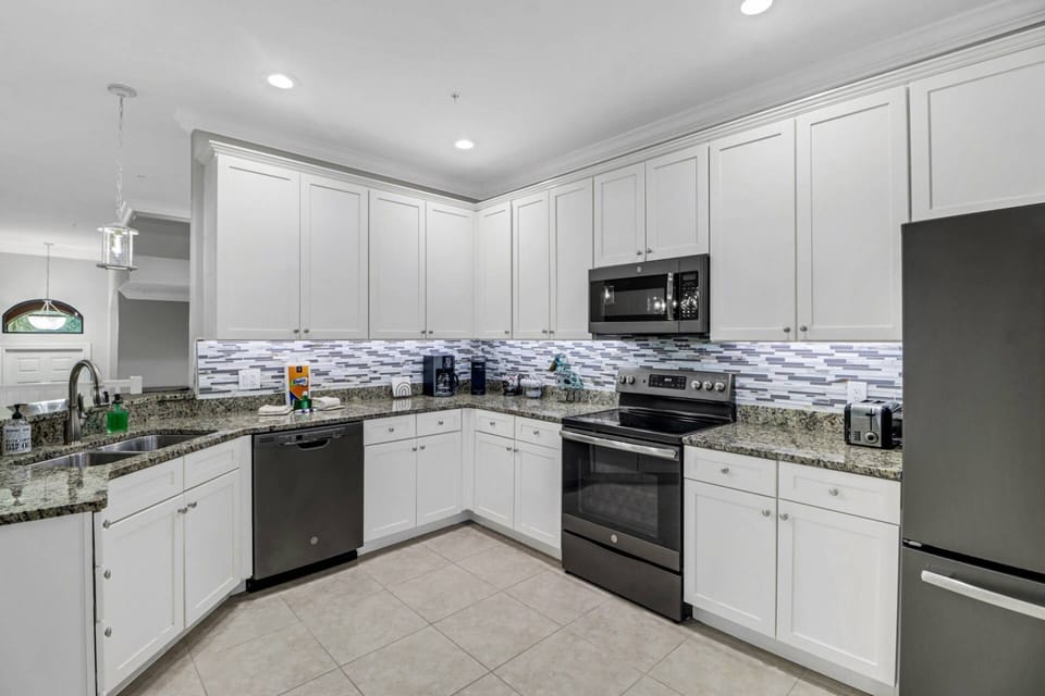 The open kitchen has abundant cabinet and counter space, upgraded appliances and a pantry.