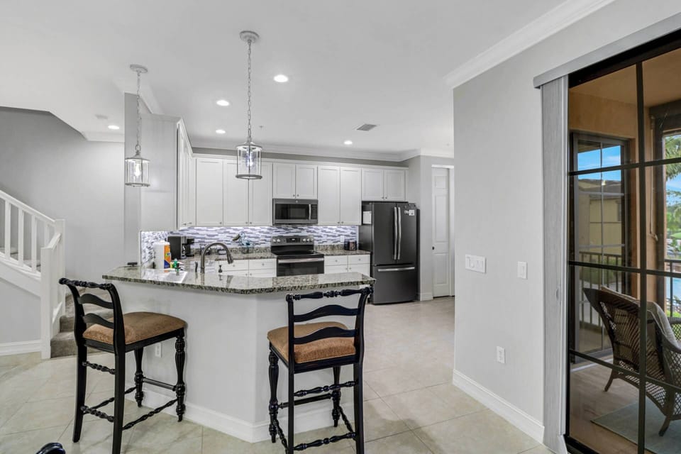 An eating bar with 2 bar stools separates the kitchen from the dining area.
