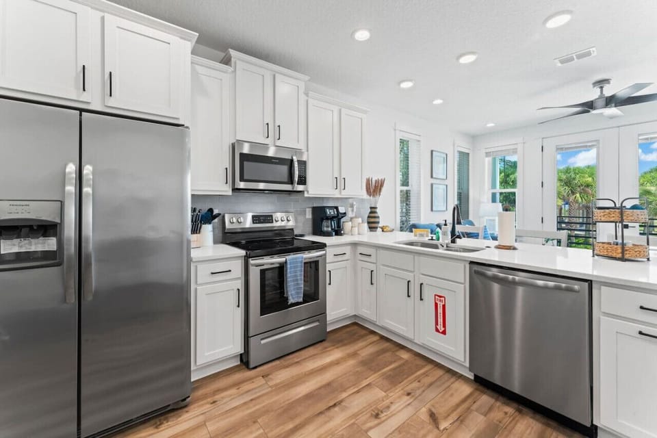 Cook, sip, and gather! This open-concept kitchen features brand-new appliances, full cookware, a drip/K-Cup coffee maker, and seating at both the dining table and bar.