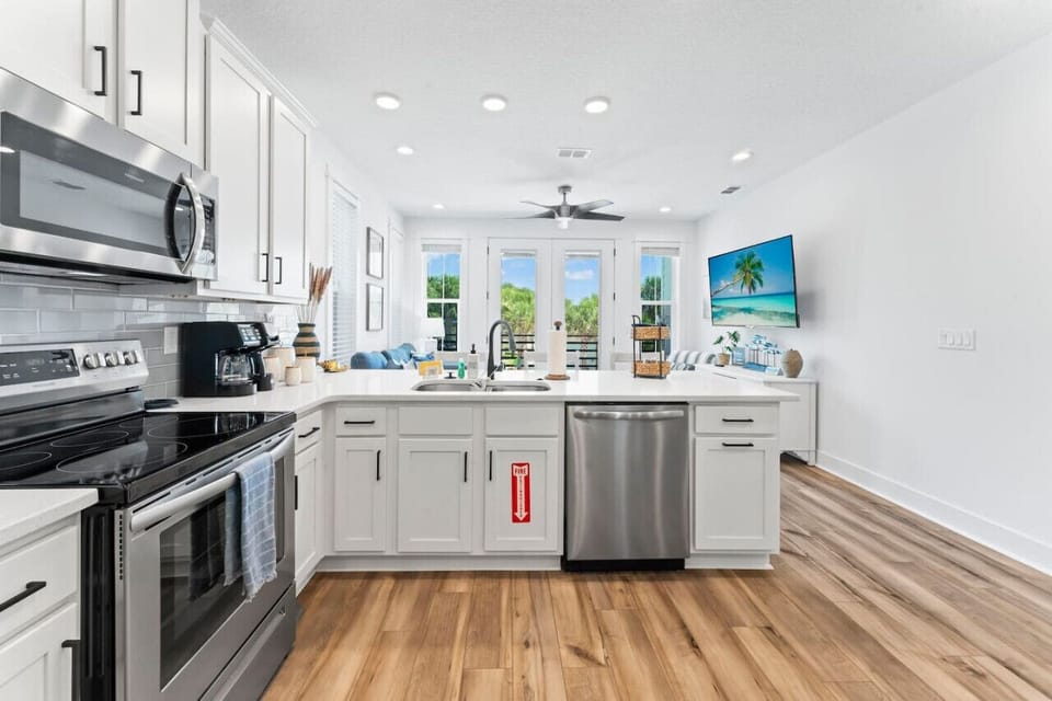Fully stocked open kitchen with all-new appliances, cookware, and a dual drip/K-Cup coffee maker—plus seating at the bar and dining table for easy meals and conversation.
