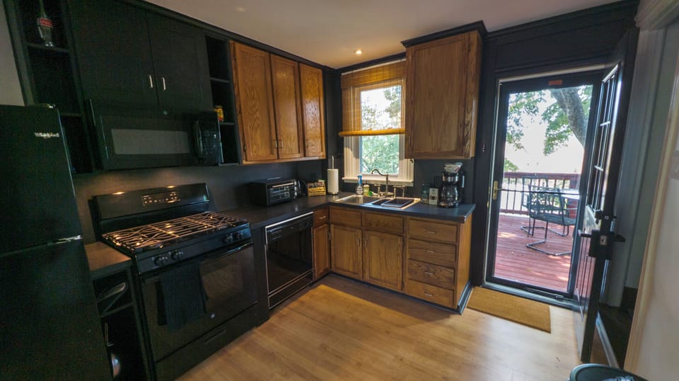 Full kitchen opens out to deck with outdoor seating.