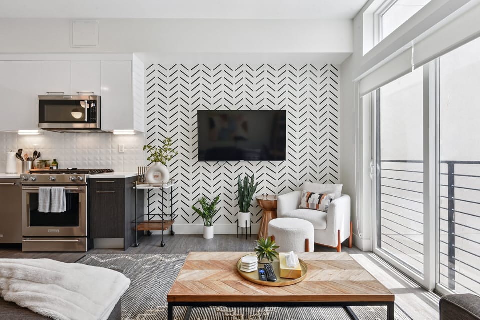 Comfortable living area with plush sofa, accent wall, and floor-to-ceiling windows at EcoLoft Retreat.