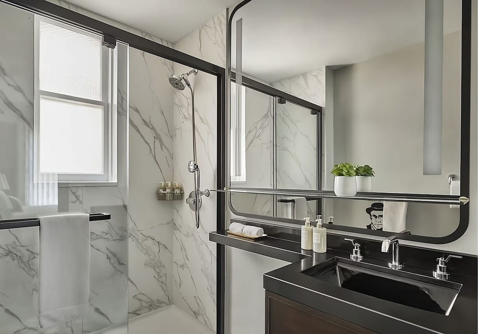Refresh in a bright marble bath with spacious walk-in shower.