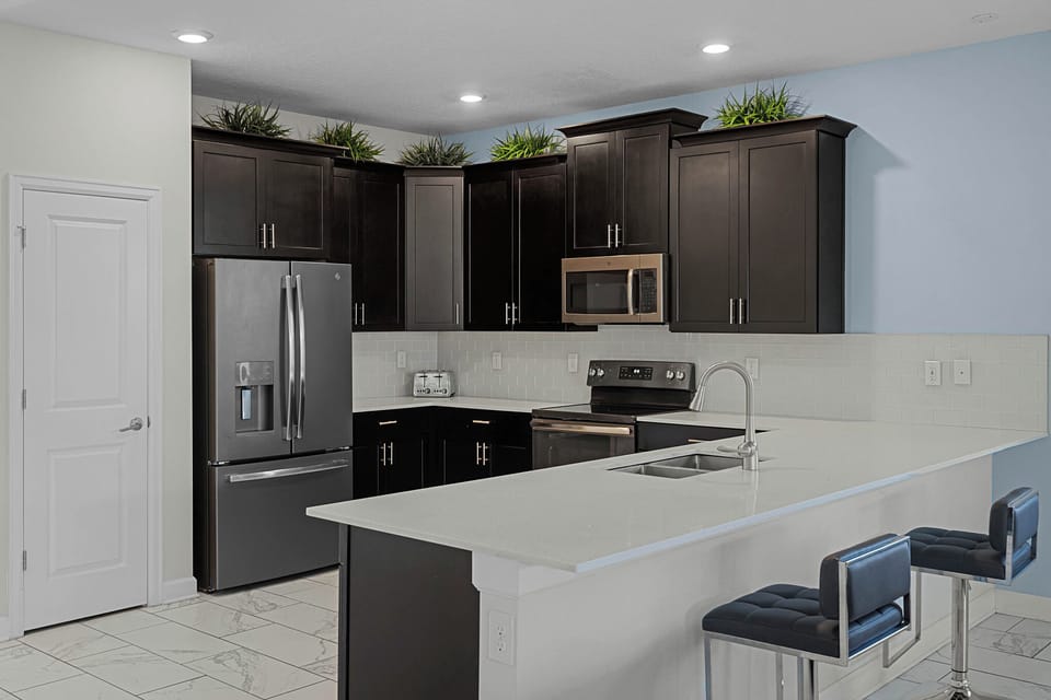 - Fully equipped kitchen with stainless steel appliances  
- Spacious counters and breakfast bar with seating  
- Ideal for cooking family meals during your Orlando stay