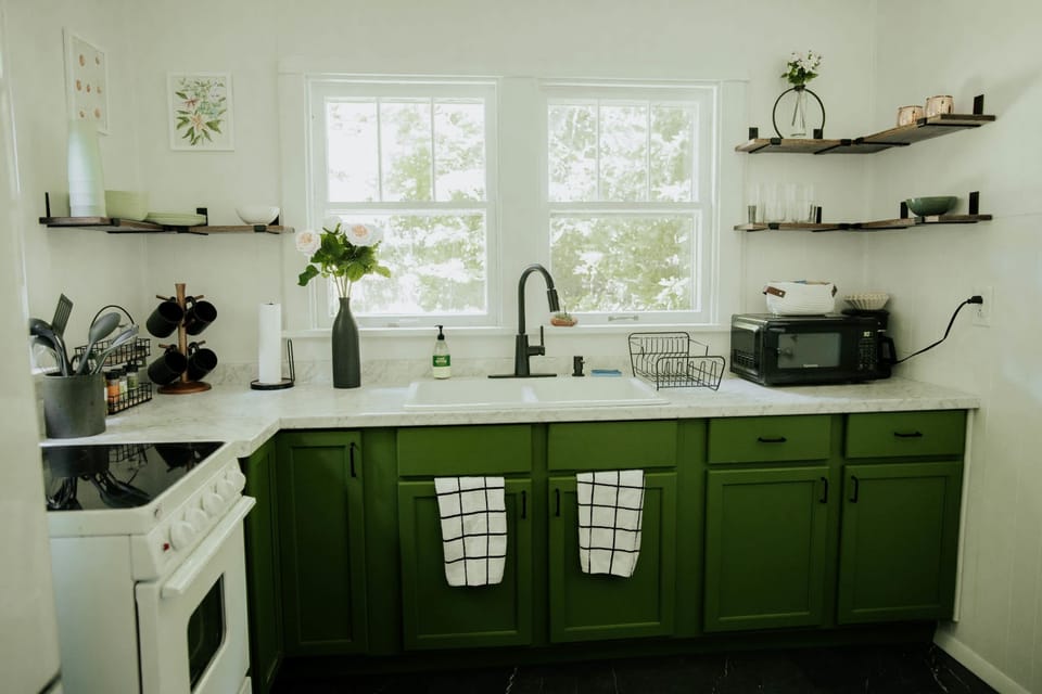 Kitchen: Whip up culinary delights in a vibrant green space with marble accents and charming decor!