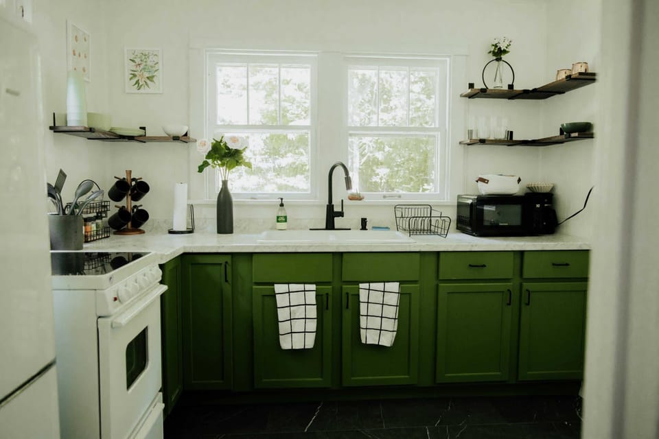 Kitchen: Whip up culinary delights in this vibrant green oasis with sleek marble countertops!