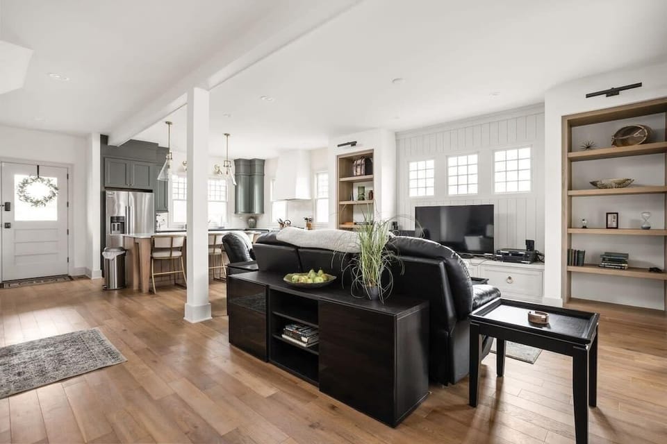 Living Room: Bright and airy space perfect for relaxation, featuring stylish shelving and light wood floors.