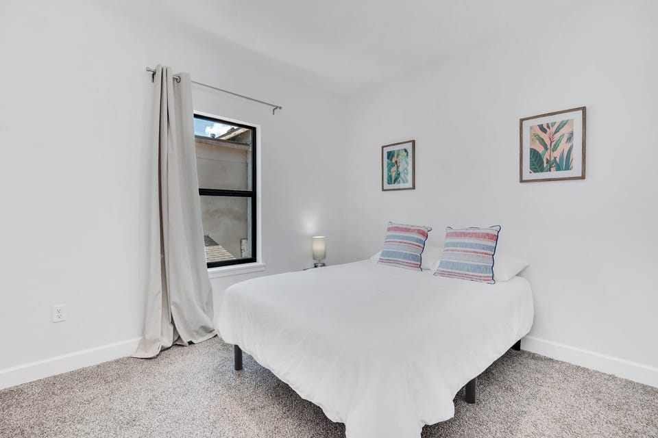 Another bedroom with plush bed and modern simplistic decor. 