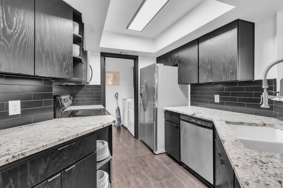 Kitchen features a traditional coffee maker, flat top cook stove, dishwasher, refrigerator