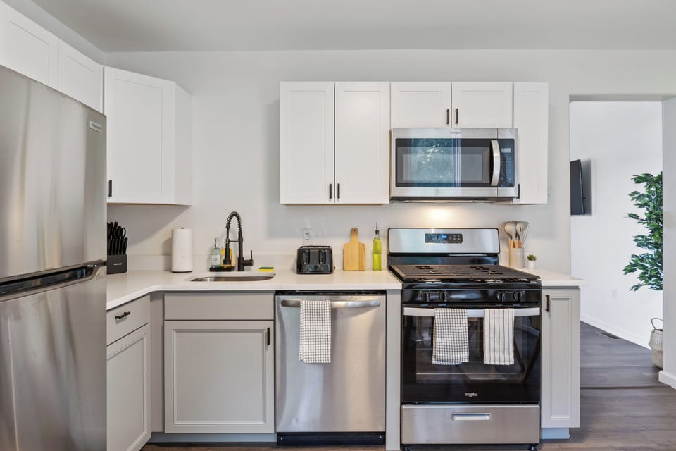Fully equipped kitchen with stainless steel appliances, microwave, gas stove